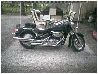 1993 Ford Bronco - A black cruiser motorcycle is parked outdoors under a canopy.