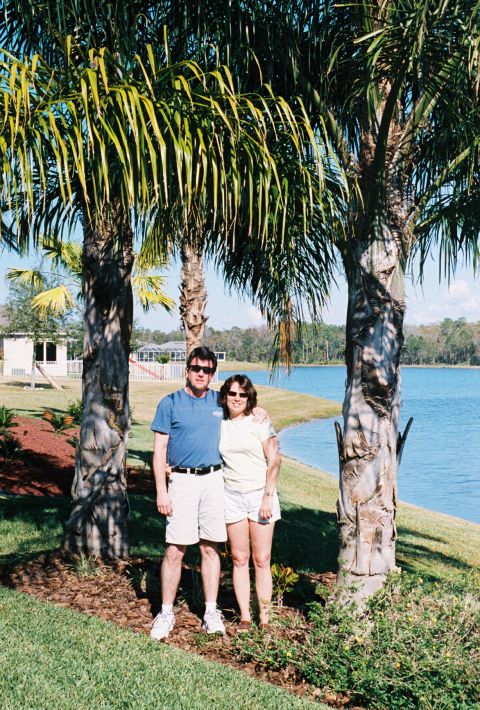 1994 Ford Bronco - A couple poses for a photo in front of a lake, with palm trees providing shade.
