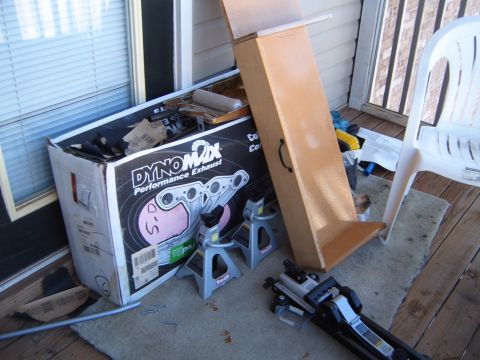 1988 Ford Bronco - A Dynomax Performance Exhaust box sits on a porch with automotive tools.