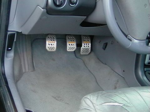 1995 Ford Contour - Aftermarket pedals installed in a car's footwell, with 'Momo' branding visible on one pedal.
