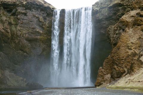 1993 Ford Bronco - A waterfall plunges over a cliff, with a rocky landscape surrounding it.