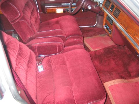 1988 Mercury Grand Marquis - The plush velour interior of a 1988 Mercury Grand Marquis, wood grain accents and a bench seat.