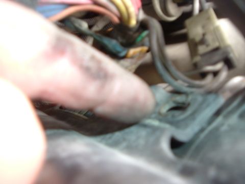 1993 Ford Taurus - A close-up view of a vehicle's engine wiring harness, with a finger obscuring part of the view.