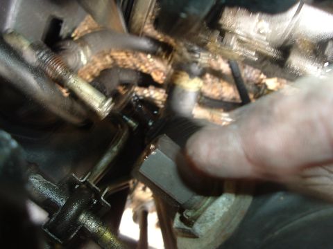 1993 Ford Taurus - A finger is seen touching a greasy engine component in this close-up view.