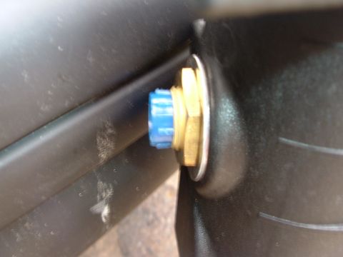 1993 Ford Taurus - A blue plastic cap is secured to a brass fitting, attached to a black component.