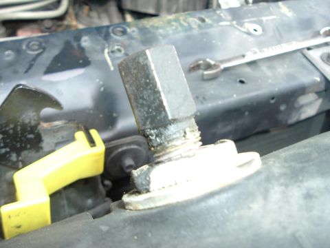 1993 Ford Taurus - Close-up of a radiator cap fitting with a wrench resting on the support structure above.