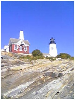 1993 Ford Bronco - A lighthouse and its adjacent keeper's house stand on a rocky outcrop against a bright blue sky.