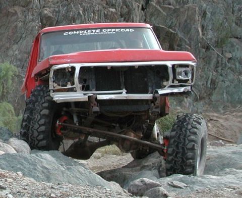 1985 Ford Bronco - This modified Ford truck is shown off-roading over rocks in a desert environment.