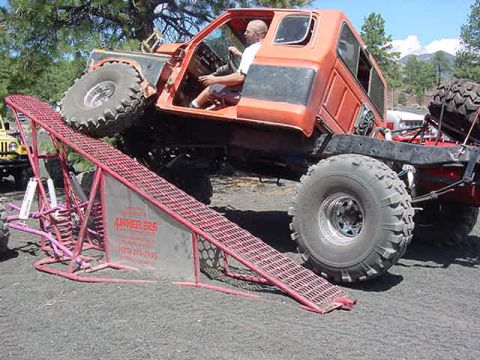 1985 Ford Bronco - This heavily modified truck is positioned on a ramp, likely for an off-road event or demonstration.