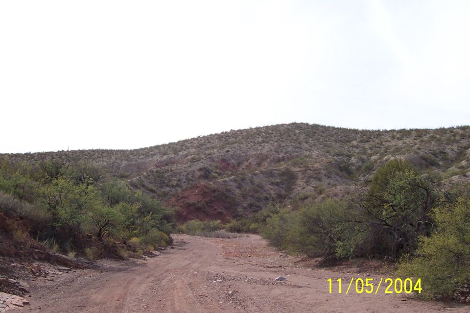 Dirt road winding through desert hills under a bright sky