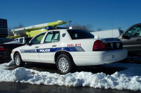 2001 Ford Crown Victoria - A white police cruiser is parked in the snow, showing its side profile and rear quarter panel.