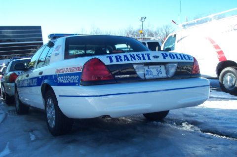 2001 Ford Crown Victoria - A 2001 Ford Crown Victoria police car is parked on a snowy surface, with another vehicle visible to its left.