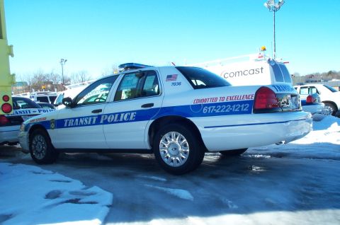 2001 Ford Crown Victoria - A 2001 Ford Crown Victoria police car, marked 'TRANSIT POLICE', is parked in a snowy lot next to another police vehicle.