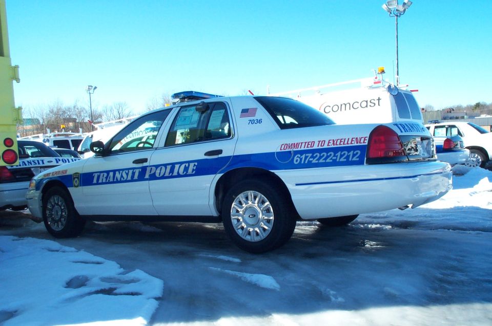 White 2001 Ford Crown Victoria police car with blue stripe and 'TRANSIT POLICE' text
