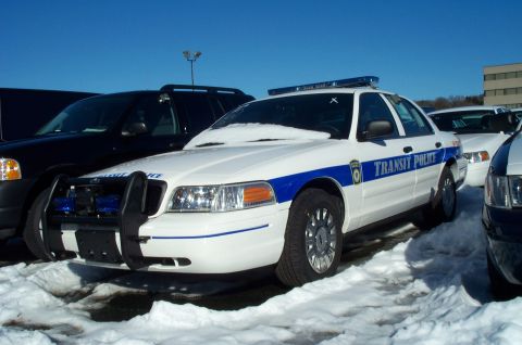 2001 Ford Crown Victoria - Ford Crown Victoria police car with "TRANSIT POLICE" markings, parked in snow next to other vehicles.