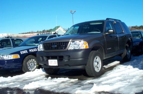 2001 Ford Crown Victoria - A Ford Explorer is parked in a snowy lot next to a police vehicle.