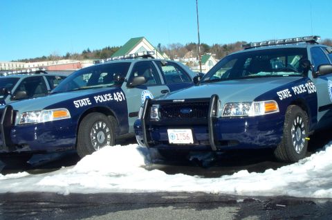 2001 Ford Crown Victoria - Several Ford Crown Victoria police cruisers are lined up in a snowy lot under a clear blue sky.