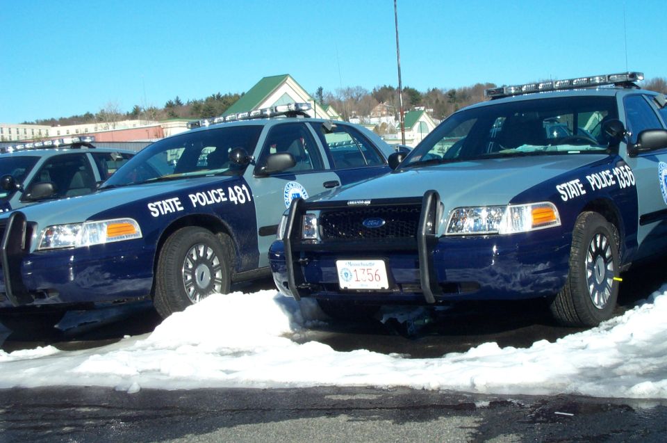 Two blue and grey Ford Crown Victoria police cars parked in snow, one with license plate 1756