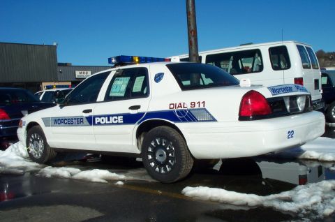 2001 Ford Crown Victoria - A Worcester Police car is parked outside on a sunny day with snow on the ground. A white van is visible behind it.