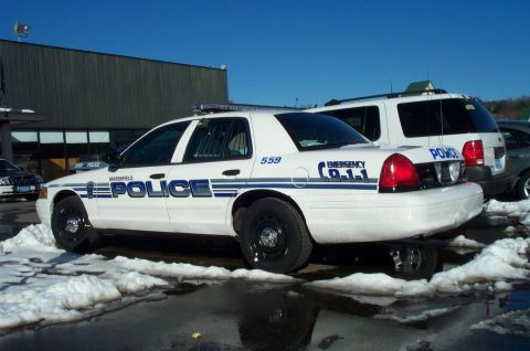 2001 Ford Crown Victoria - A white 2001 Ford Crown Victoria police car is parked in a lot with snow and ice on the ground.