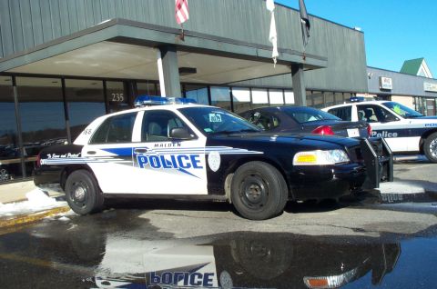 2001 Ford Crown Victoria - A 2001 Ford Crown Victoria police car is parked in front of a building, with another police car visible behind it.
