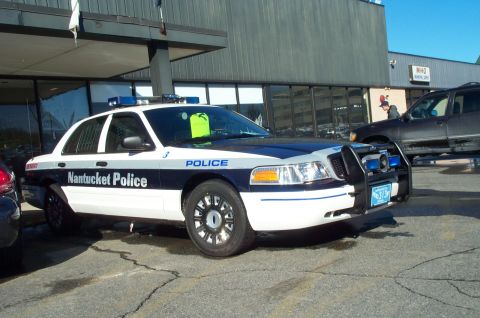2001 Ford Crown Victoria - Nantucket Police Crown Victoria parked outside a building with another vehicle nearby.