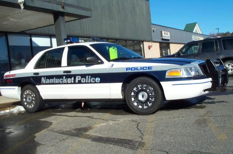 2001 Ford Crown Victoria - A Nantucket Police car is parked in front of a building, with another vehicle behind it.