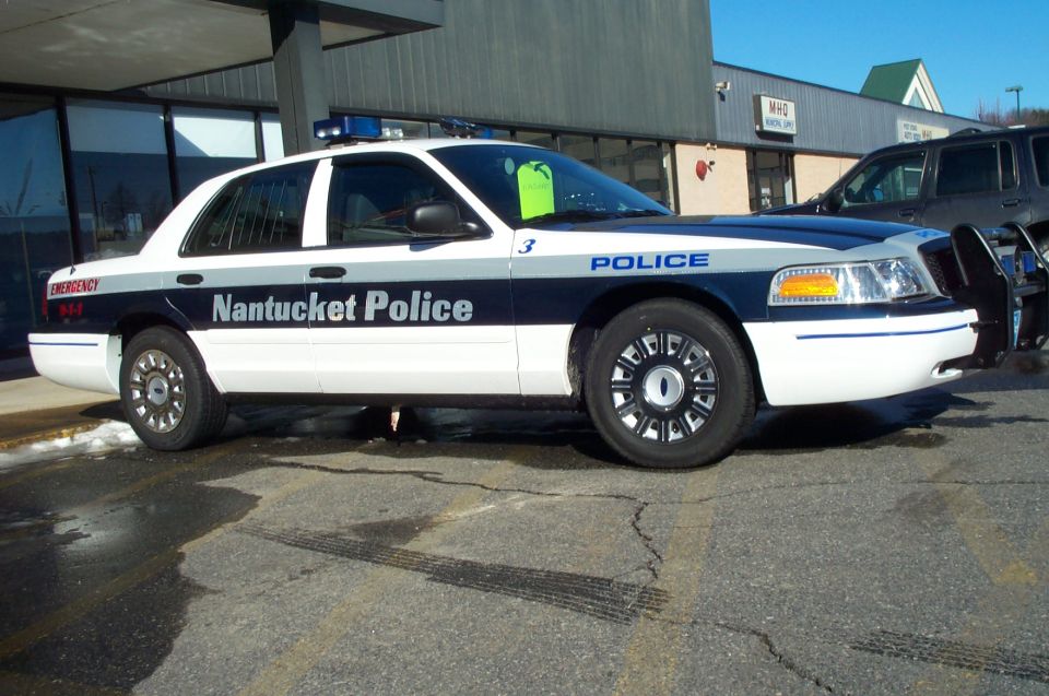 White and blue 2001 Ford Crown Victoria police car with "Nantucket Police" text, parked on asphalt
