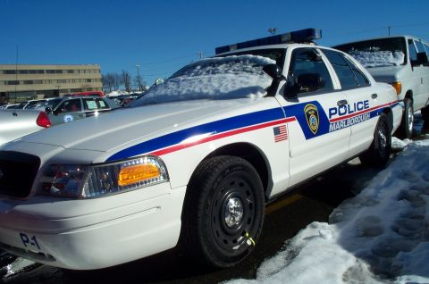 2001 Ford Crown Victoria - A 2001 Ford Crown Victoria police car, marked 'Marlborough', sits covered in snow, with another vehicle visible behind it.