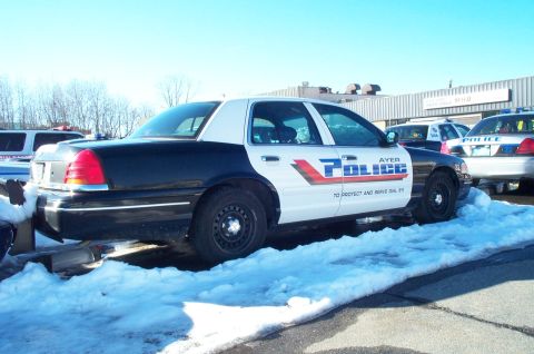 2001 Ford Crown Victoria - Ayer Police car, a 2001 Ford Crown Victoria, is parked in the snow with other police vehicles visible.