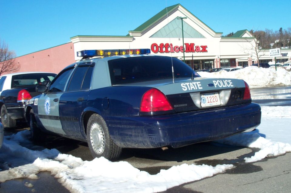 2001 Ford Crown Victoria police car, rear view, parked in snow with OfficeMax in background