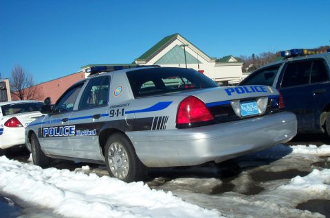 2001 Ford Crown Victoria - A police car is parked in the snow next to another police vehicle.