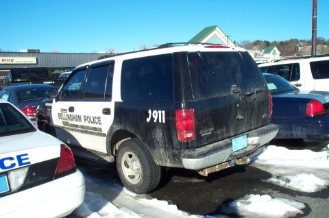 2001 Ford Crown Victoria - A police SUV with 'Bellingham Police' and '911' markings is parked in a snowy lot.
