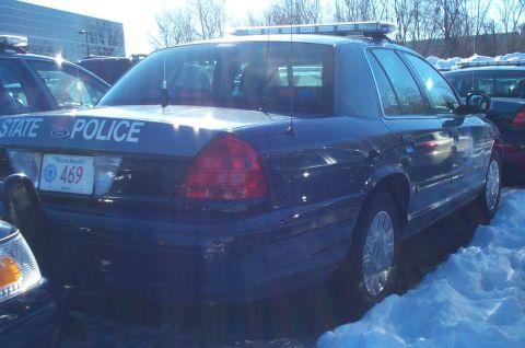 2001 Ford Crown Victoria - Dark blue Ford Crown Victoria police car parked in snow, showing 'STATE POLICE' text and license plate.