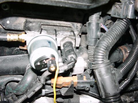 1998 Volkswagen Jetta - Close-up view of various engine components, including sensors and hoses, within a vehicle's engine bay.