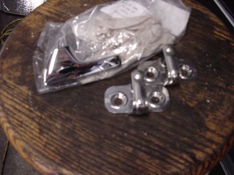 1998 Volkswagen Jetta - Close-up of new door hinges packaged for sale, resting on a wooden surface.
