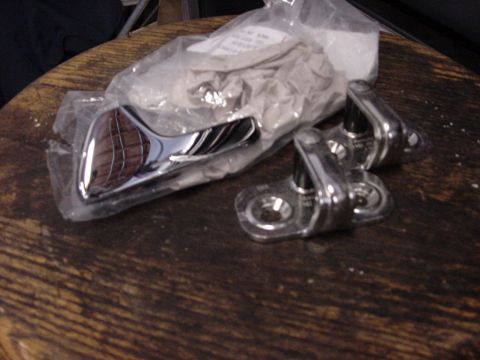 1998 Volkswagen Jetta - New chrome door handle and hinges are packaged on a wooden table.
