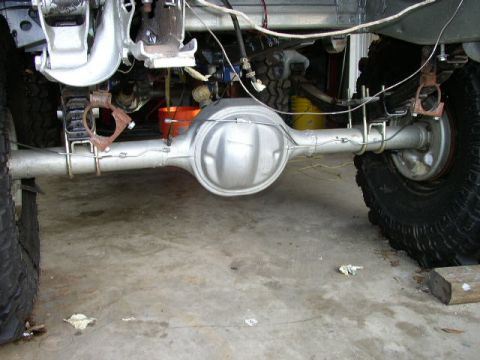 1995 Ford Bronco - Close-up view of the rear axle and suspension system of a vehicle, likely undergoing maintenance or repair.