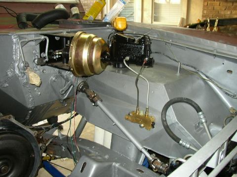 1995 Ford Bronco - Close-up view of the brake booster and master cylinder assembly within a vehicle's engine compartment.