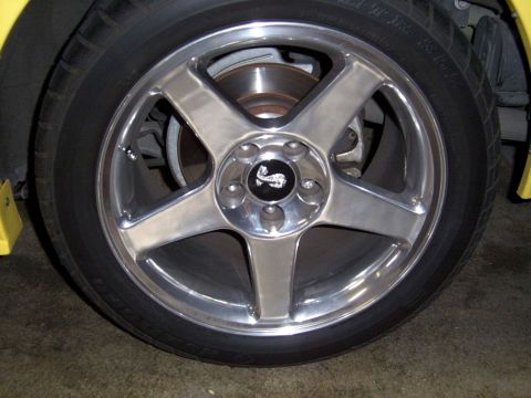 2002 Ford Mustang - Close-up of a chrome wheel a black center cap with a cobra emblem.