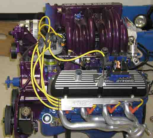 Ford V8 engine with purple intake manifold and silver valve covers that say "POWERED BY FORD"