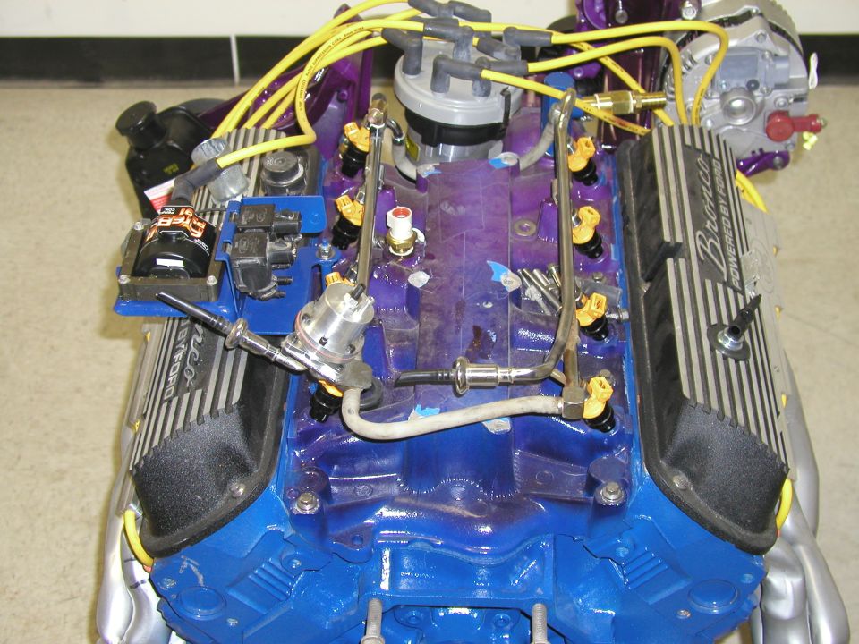Ford Bronco engine with fuel injectors and yellow spark plug wires. Valve cover reads 'Bronco Powered by Ford'