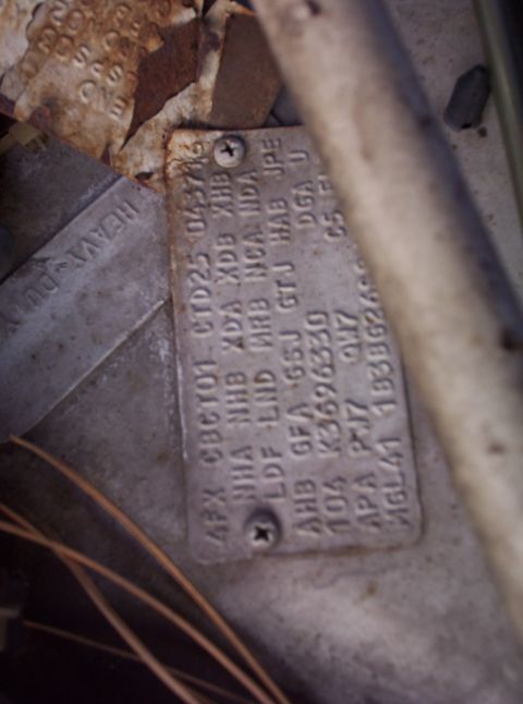 1991 Ford LTD Crown Victoria - Close-up of a vehicle identification plate with various codes and numbers stamped into it.