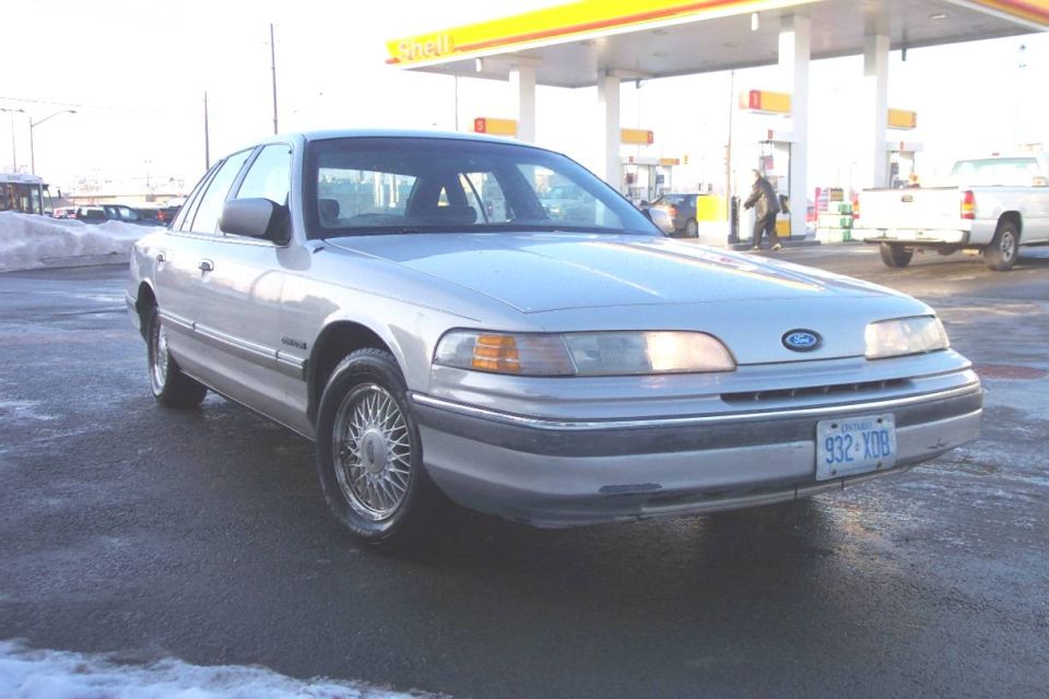 1992 Ford Crown Victoria at a gas station with a white pickup truck in the background