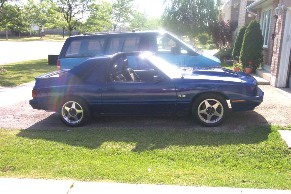 Side profile of a blue Fox-body Mercury Capri 5.0 on a driveway