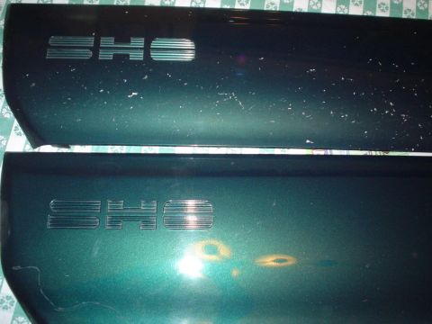 1993 Ford Taurus - Two car door trim pieces with "SHO" emblems are shown, with visible paint damage.