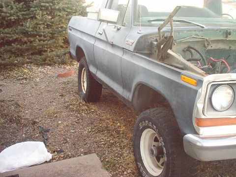 1991 Ford Bronco - This gray pickup truck, seen from a 3q-front angle, has its hood open and tires marked 'Safari'.