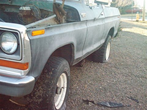 1991 Ford Bronco - This 1978 Ford Bronco has a flat rear tire and the hood is open, revealing the engine bay.