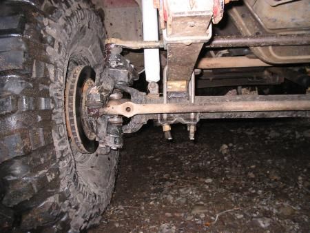 1983 Ford Bronco - This image shows the undercarriage of a vehicle, focusing on the front suspension and a large tire.