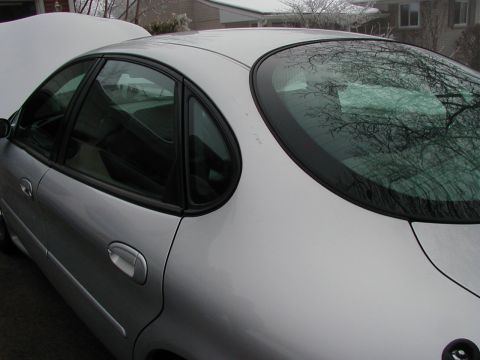 1997 Ford Taurus - Side profile of a silver 1997 Ford Taurus sedan, showing the doors and rear window.